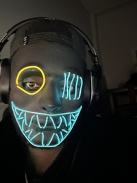 a man wearing a neon mask and headphones